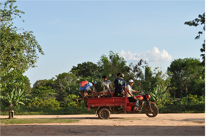 The boys getting onto the tuk tuk and going for a ride to a local football match.