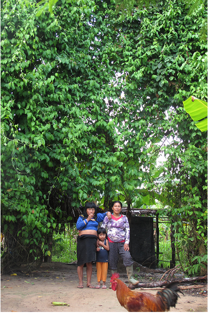 Mama ida, the mother of my late shaman Roger Lopez with a large Ayahuasca vine gorwing behind them. Mama ida had the most esqusite medicinal garden.